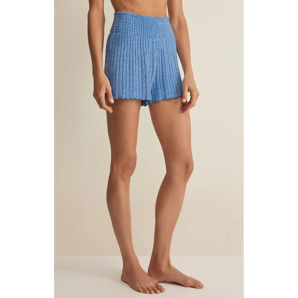 Person wearing blue shorts on a beige background