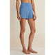 Person wearing blue shorts on a beige background